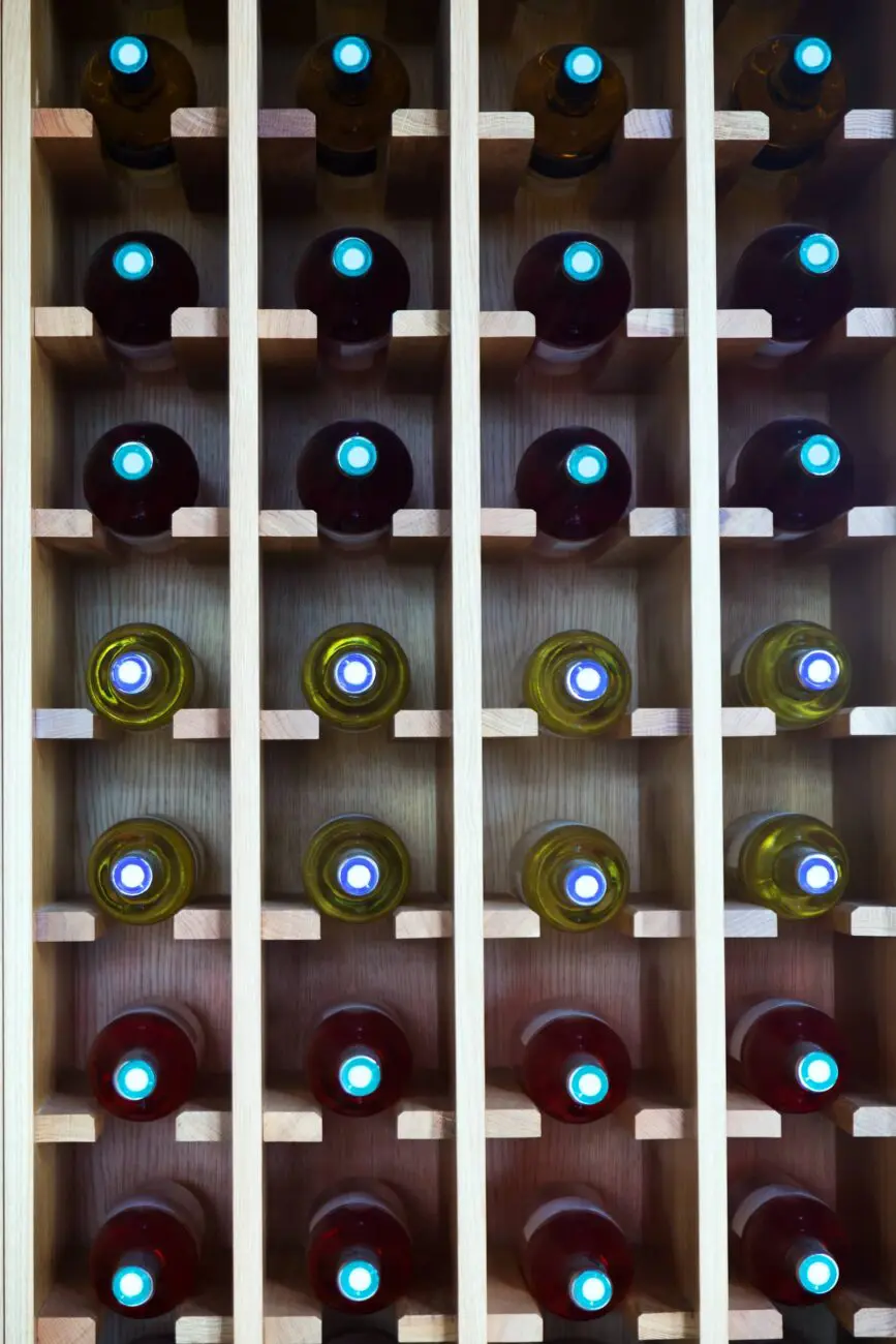 Vue de face d'un casier à bouteilles en bois clair montrant la conservation optimale du vin à l'horizontale dans une cave.
