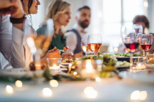 Verres de vin rosé sur une table de mariage décorée avec des bougies lors d'un dîner de réception.