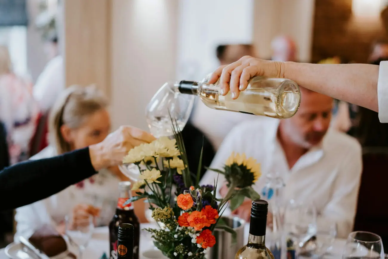 Service d'un vin rosé à table lors d'un repas de mariage organisé avec l'expertise de vins-mariages.net.