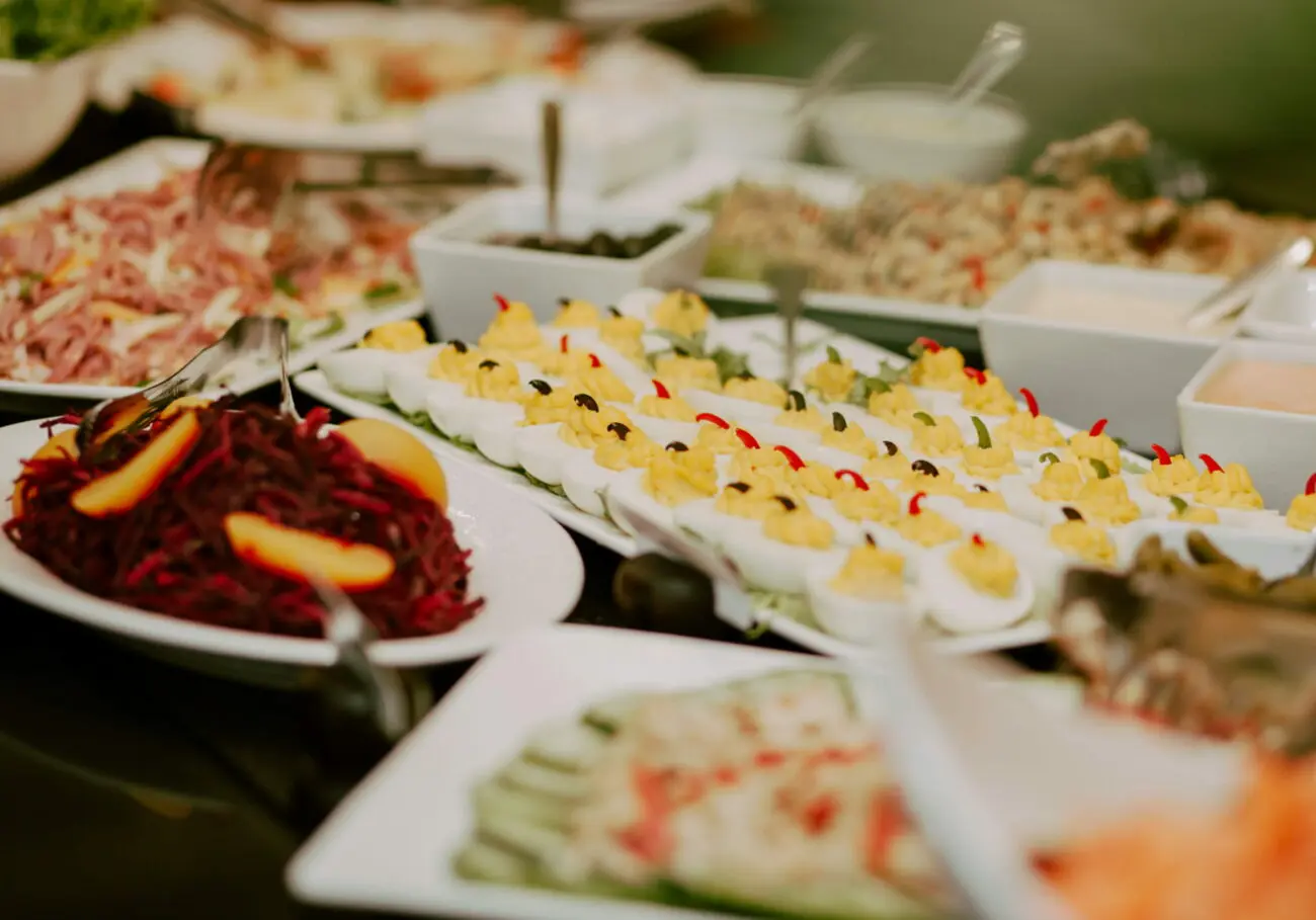 Buffet de brunch de mariage avec œufs mimosa, salades composées et crudités, idéal pour un accord avec les vins blancs de vins-mariages.net.
