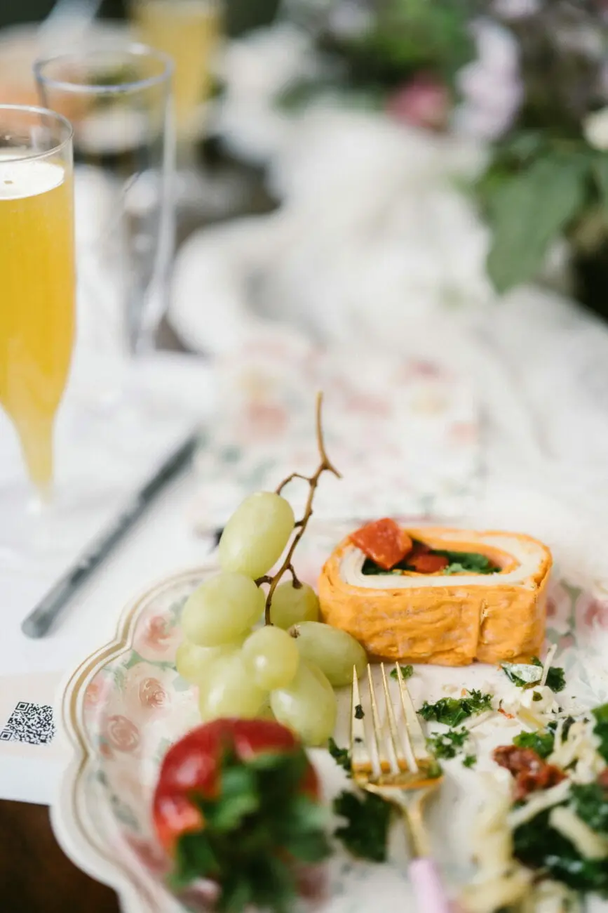 Assiette de brunch de mariage avec raisins, fraise et roulé salé accompagnée d'une coupe de vin pétillant sélectionné par vins-mariages.net.
