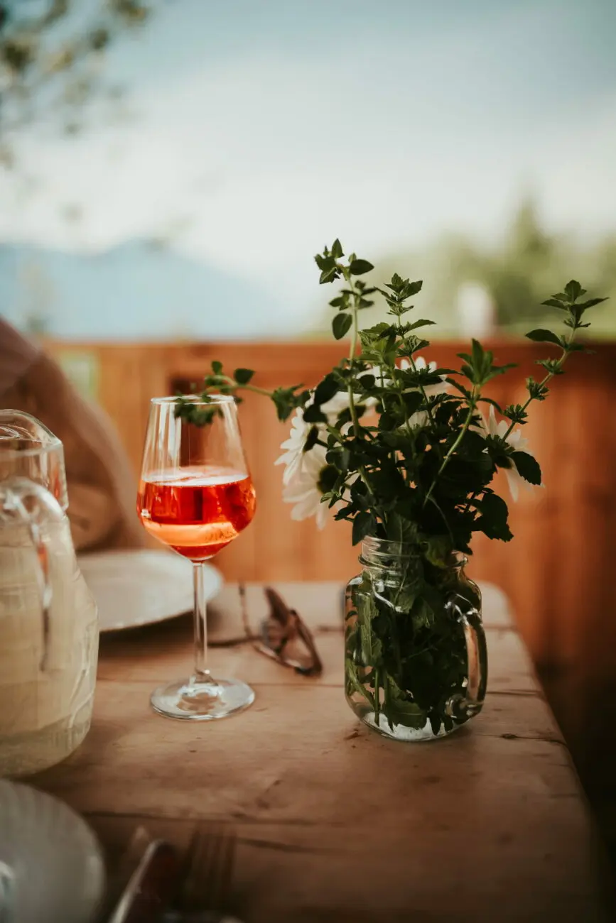 Table de mariage champêtre avec un verre de vin rosé rafraîchissant et un bouquet floral, suggestion vins-mariages.net.