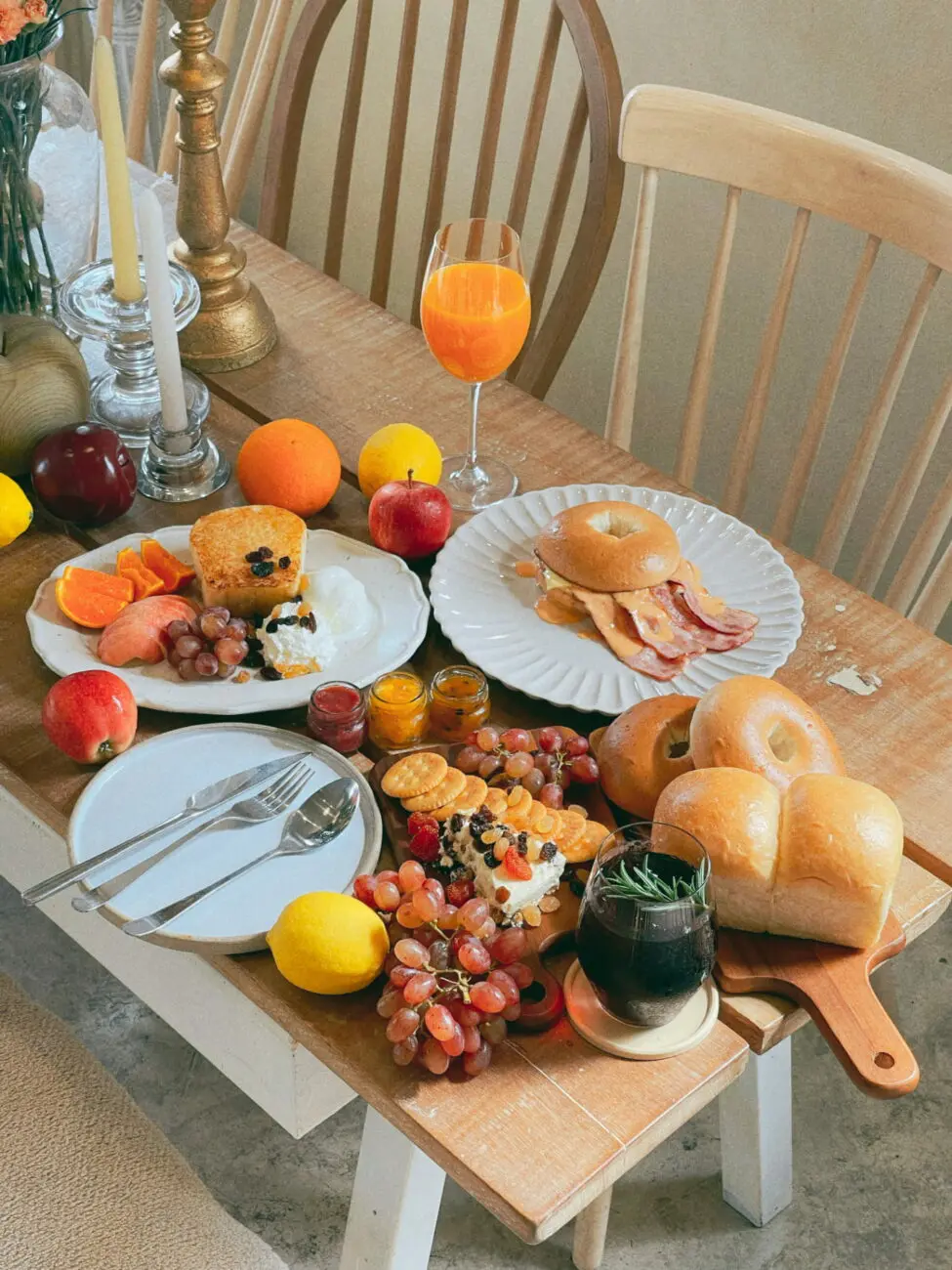 Buffet de brunch de mariage gourmand sur table en bois avec bagels, fruits, viennoiseries et jus frais, conseillé par vins-mariages.net.