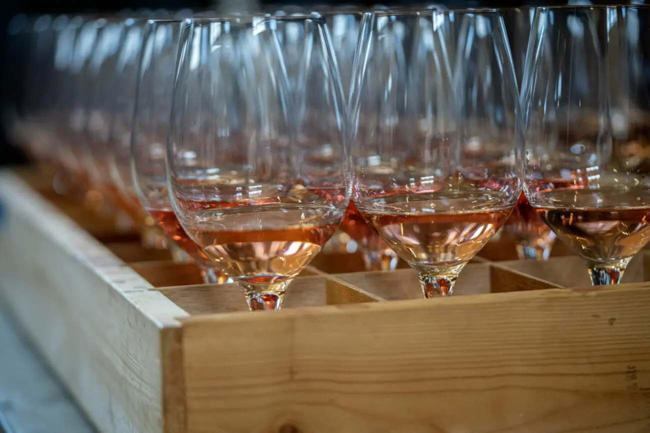 Alignement de verres de vin rosé prêts pour une dégustation de mariage, logistique vins-mariages.net pour événements.