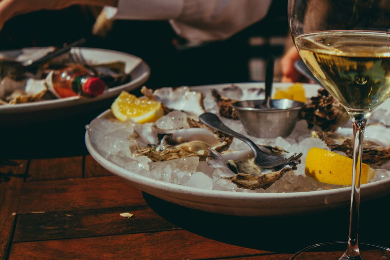Plateau d'huîtres fraîches sur glace avec citron et un verre de vin blanc sec pour un vin d'honneur de mariage.