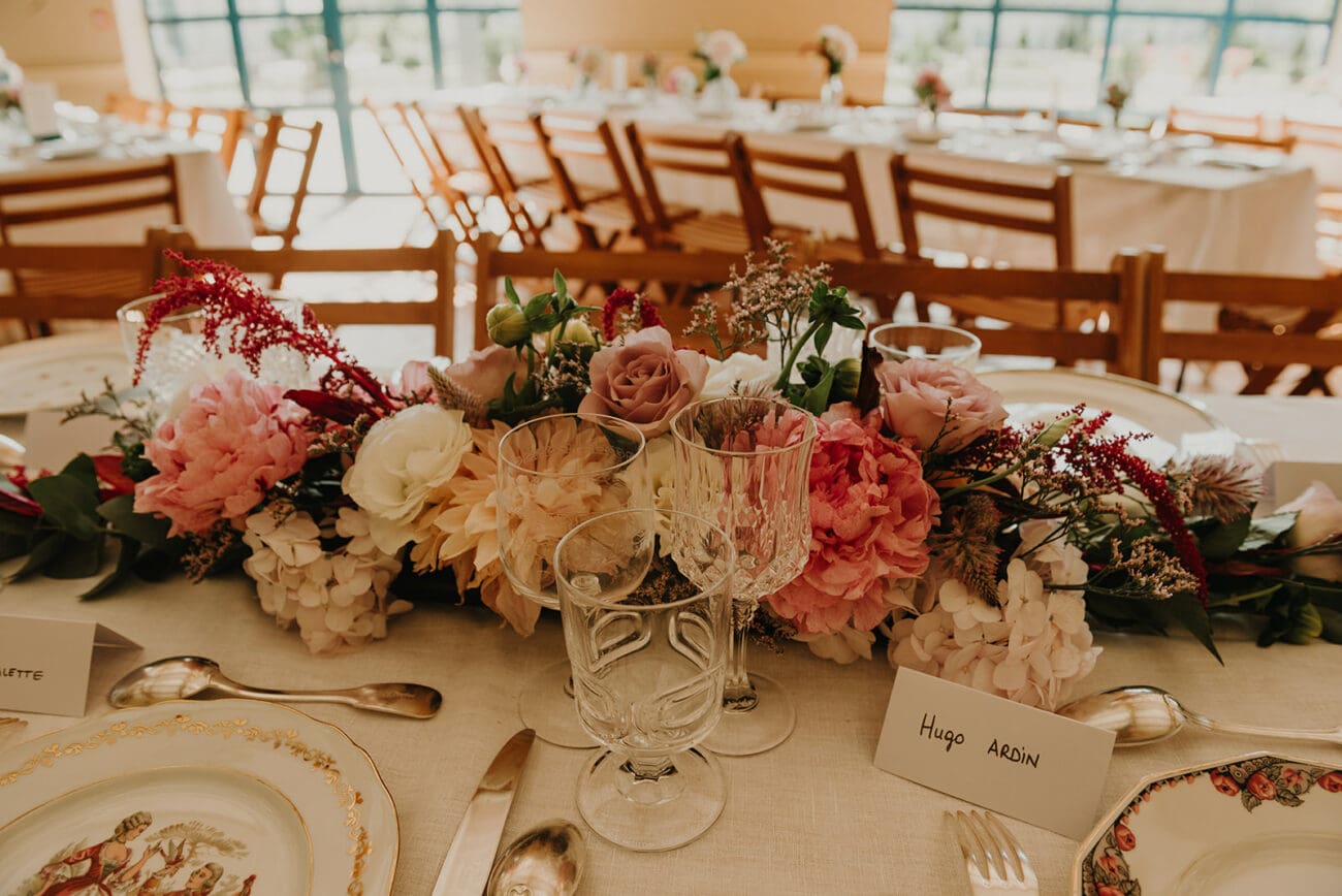 Table de réception de mariage décorée avec des verres à vin élégants et un centre de table floral rose, service de vin pour mariage.
