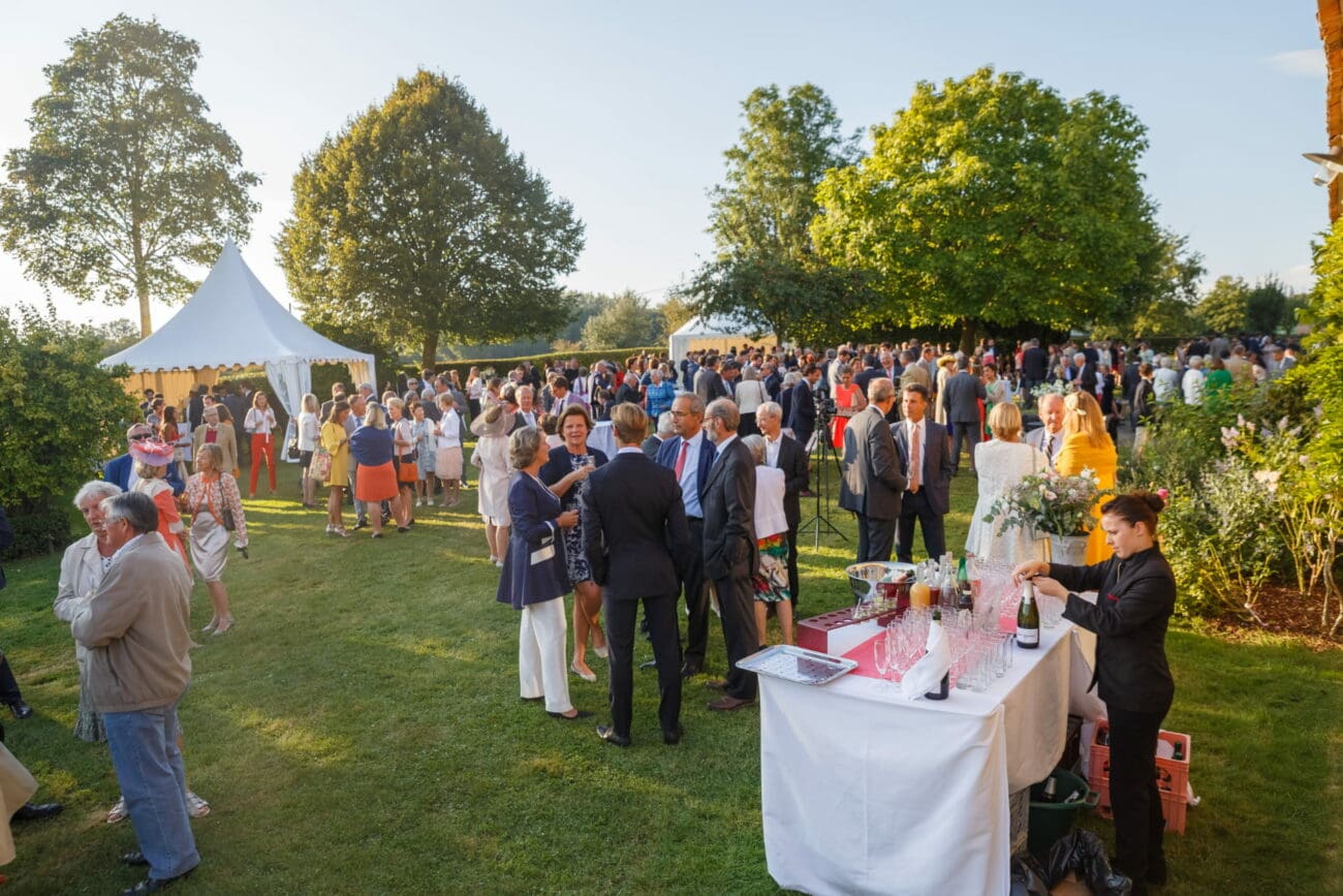 Serveuse préparant le service du vin et du champagne sur un buffet lors d'un cocktail de mariage en extérieur.