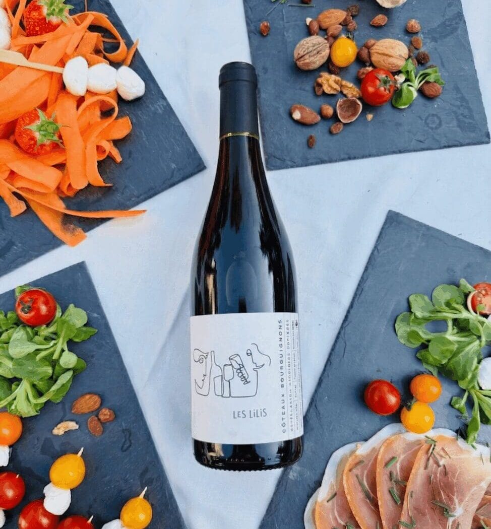 Bouteille de vin rouge Coteaux Bourguignons "Les Lilis" 2024 des Vignerons des Pierres Dorées sur un buffet de mariage.