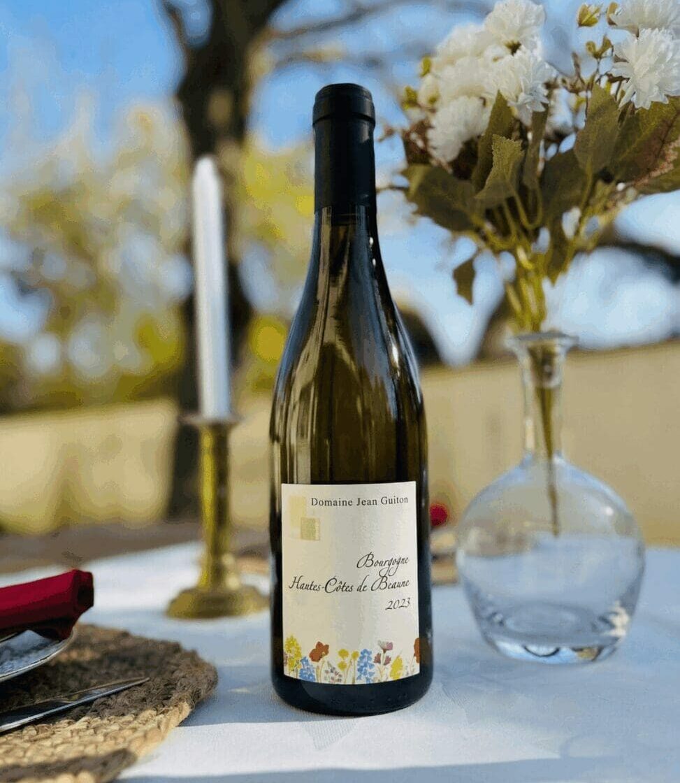 Bouteille de vin blanc Bourgogne Hautes-Côtes de Beaune 2023 du Domaine Jean Guiton sur une table de mariage décorée.