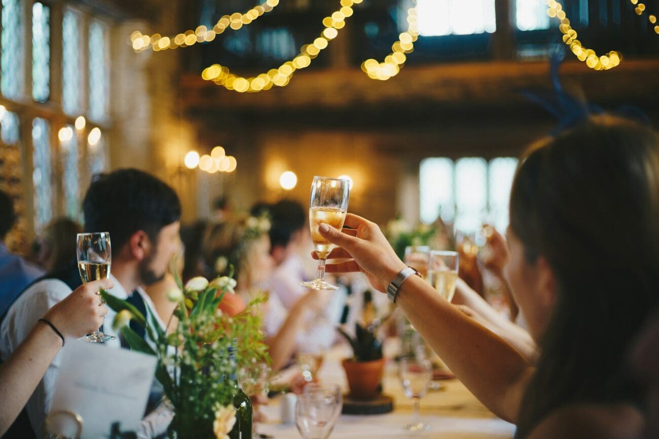 Invités de mariage portant un toast avec des verres de vin et champagne lors d'un banquet festif, sélection de vins pour mariage.