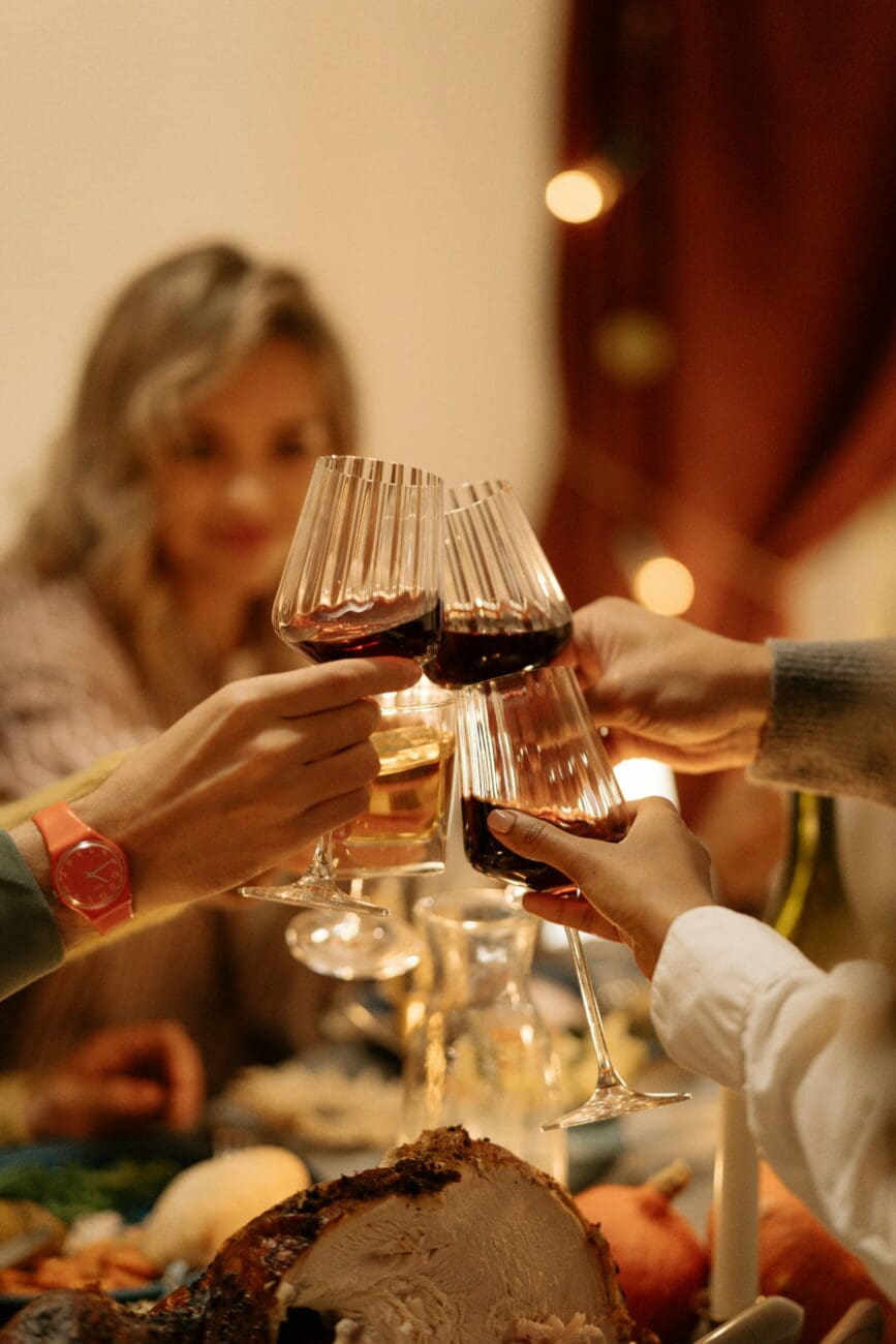 Portée de toast avec des verres de vin rouge lors d'un dîner de mariage festif et convivial.