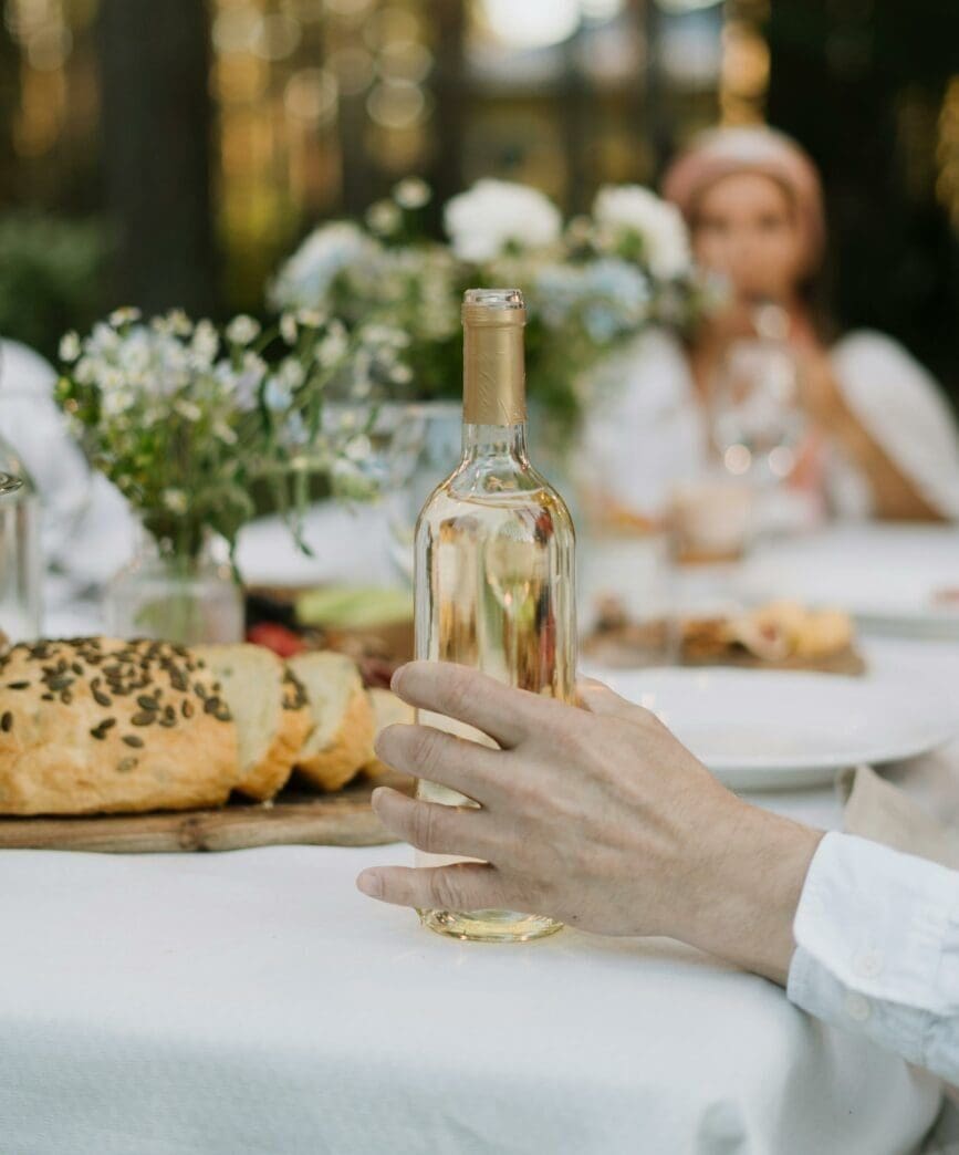 Réception de mariage en plein air avec des invités dégustant du vin lors du cocktail de bienvenue.