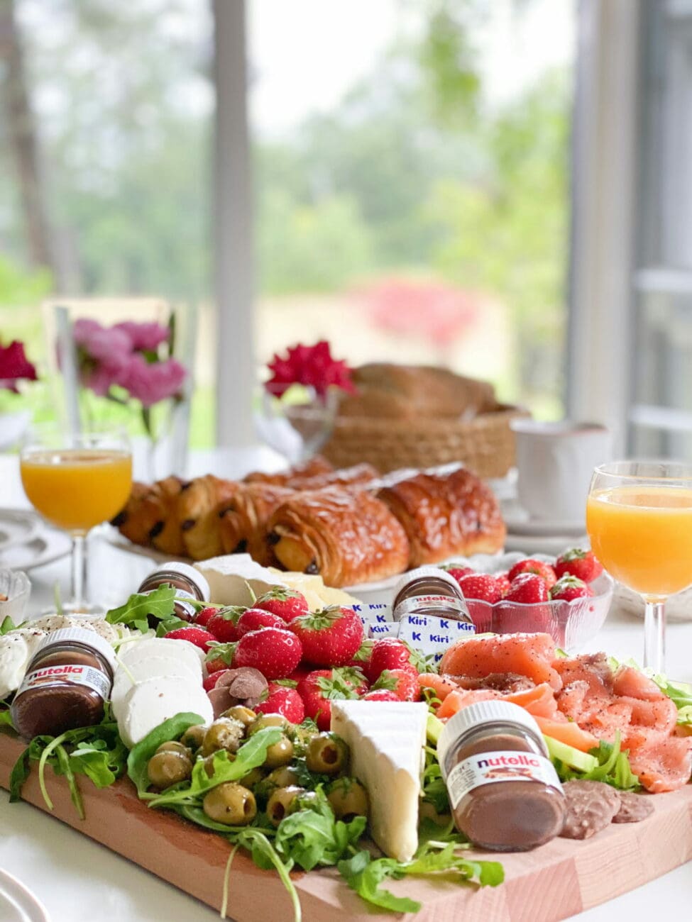 Planche de brunch de mariage avec saumon fumé, fromages, fraises et viennoiseries, accompagnée de vins blancs secs de vins-mariages.net.