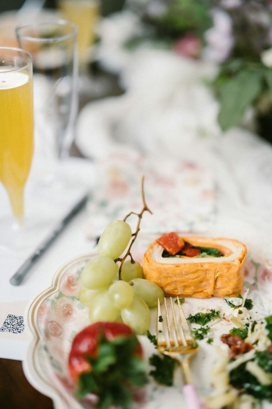 Assiette de brunch de mariage avec raisins, fraise et roulé salé accompagnée d'une coupe de vin pétillant sélectionné par vins-mariages.net.