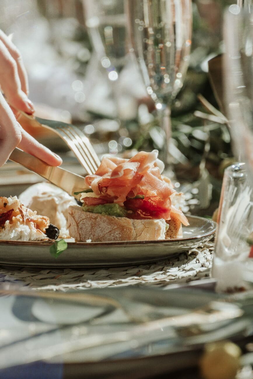 Tartine de jambon cru et avocat servie avec une flûte de vin effervescent lors d'un brunch de mariage, une recommandation vins-mariages.net.