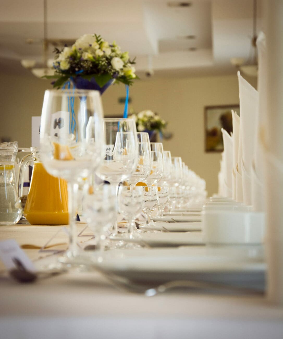 Alignement de verres à vin sur une table de brunch de mariage élégante avec compositions florales, une expertise de vins-mariages.net.