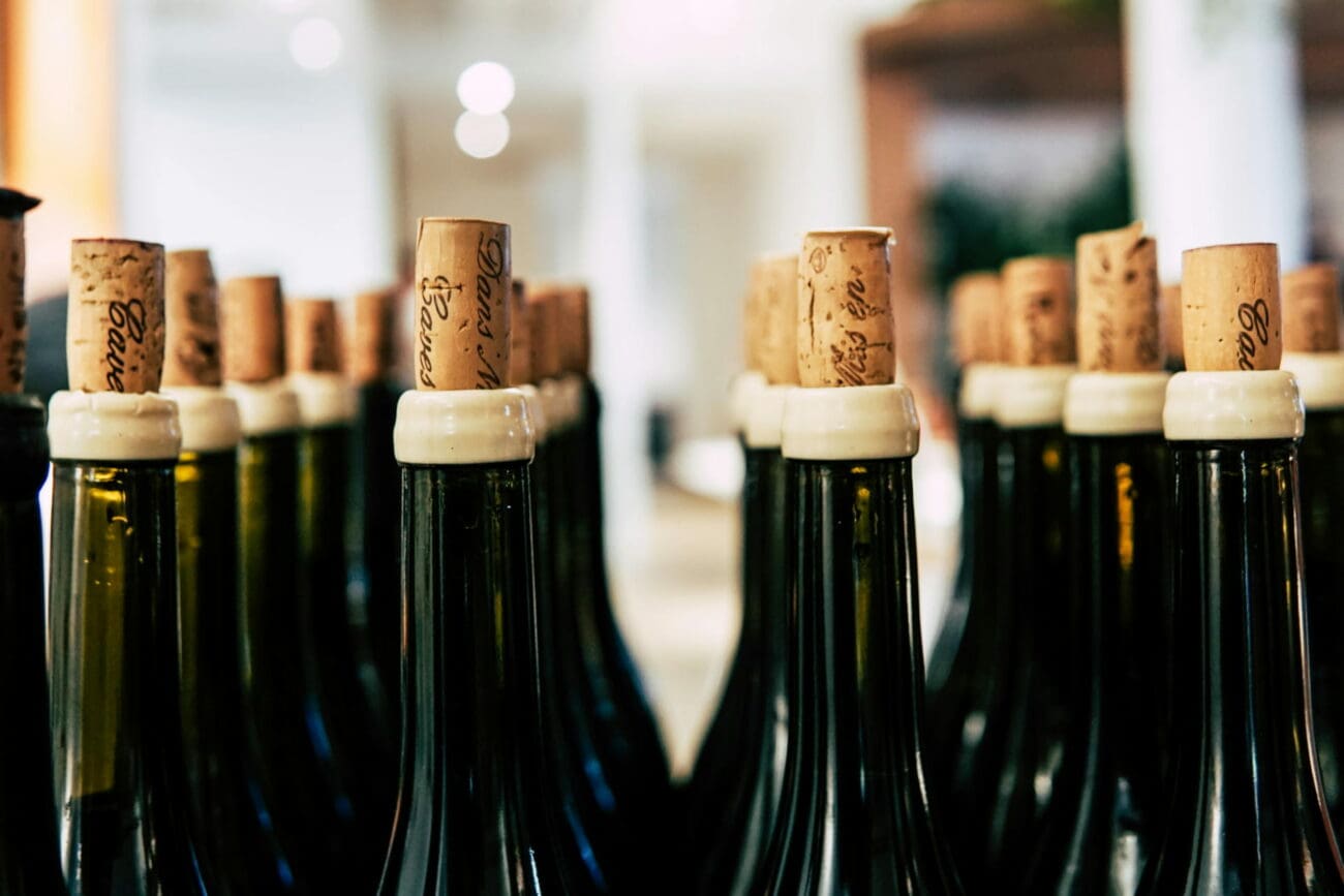 Une rangée de bouteilles de vin en verre noir avec des bouchons en liège naturels, prêtes pour une dégustation lors d'un mariage, sélectionnées par vins-mariages.net.